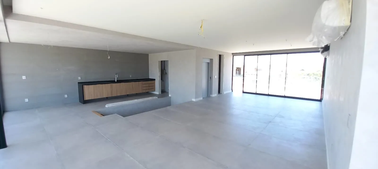 Cozinha planejada com bancada em granito preto e armários em madeira na Mansão Alphaville 1200m²