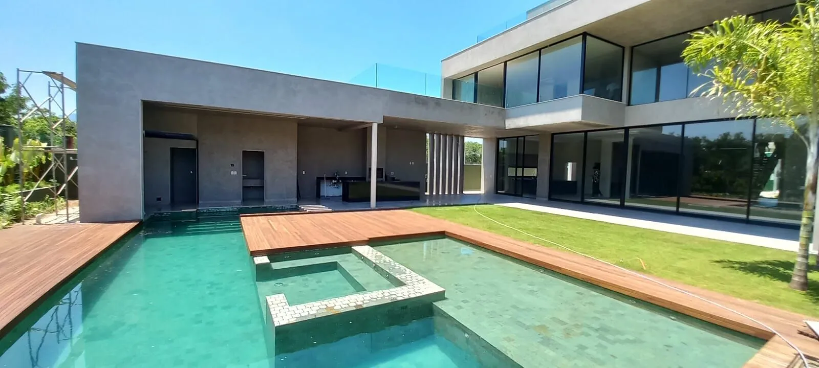 Fachada da mansão contemporânea 1200m² no Alphaville com piscina com hidromassagem, deck de madeira e arquitetura Jorge Brezinski