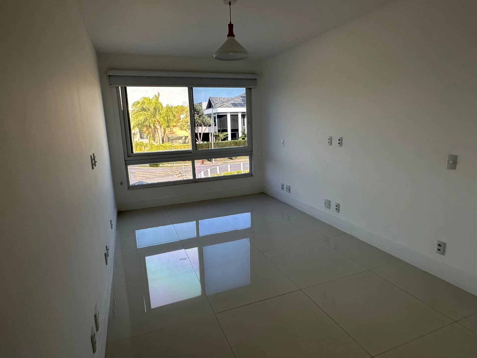 Suíte com vista para casas do condomínio Alphaville, janela com blackout e piso porcelanato polido