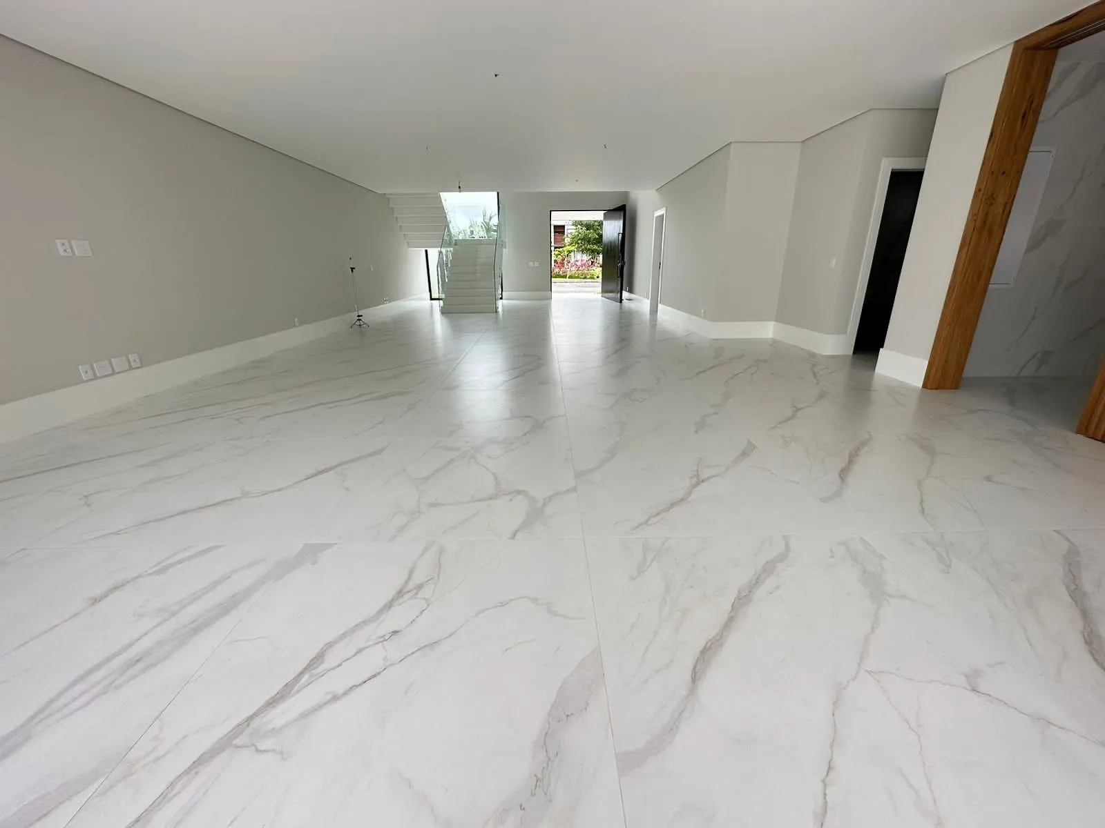 Sala de estar espaçosa com piso de mármore branco e iluminação natural