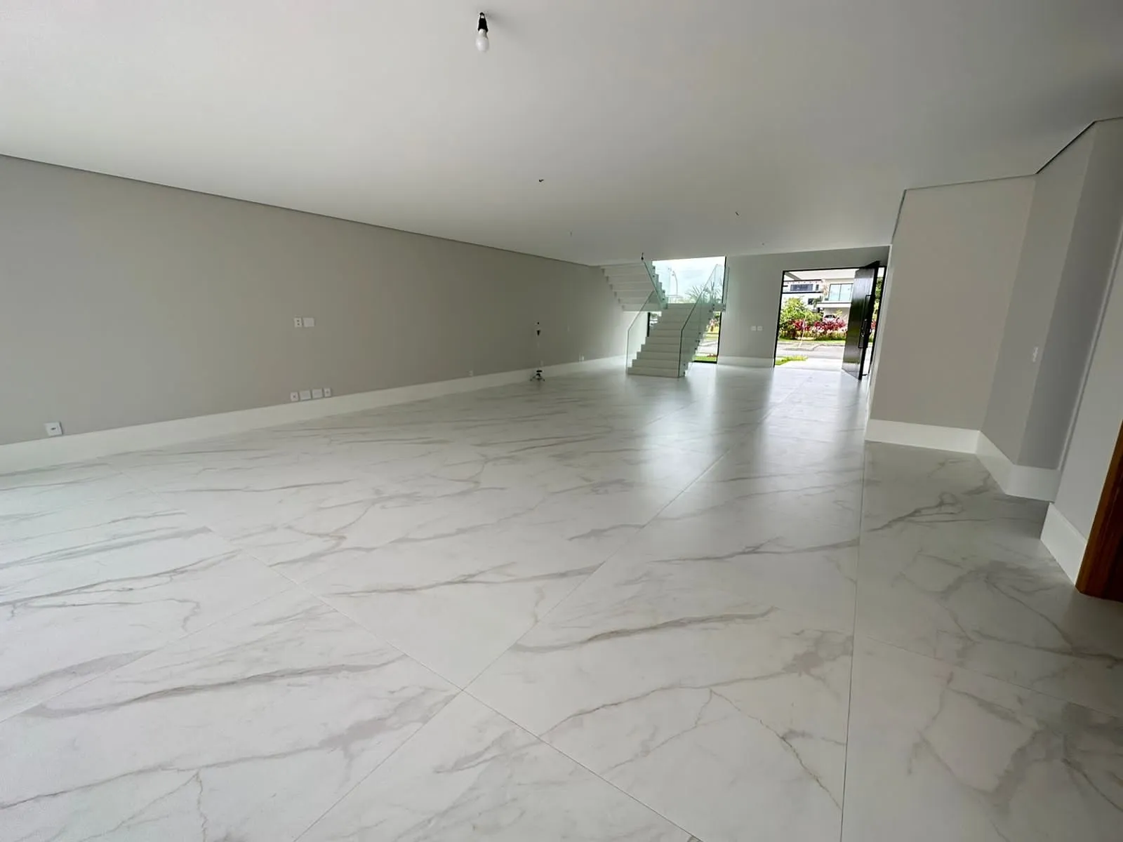 Sala de jantar e estar integrada com vista para o jardim da casa no Alphaville