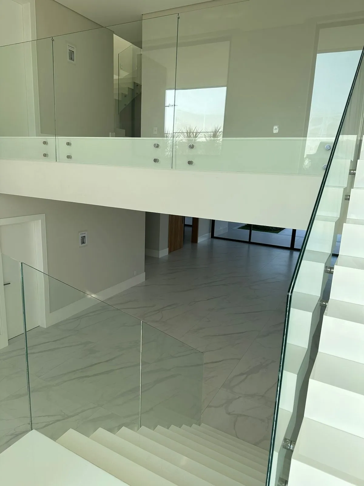 Suíte ampla com piso de mármore e iluminação natural na casa Alphaville 560m²