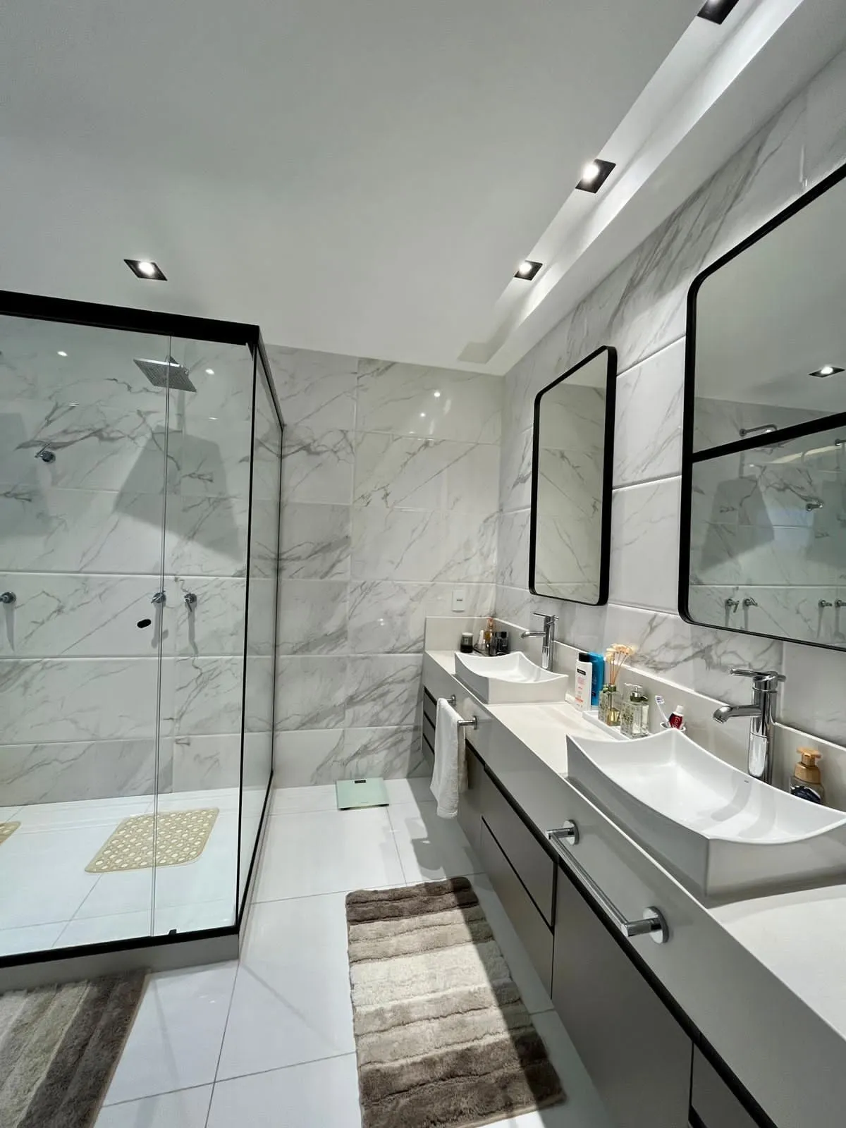 Banheiro de suíte com acabamento em porcelanato e box de vidro temperado