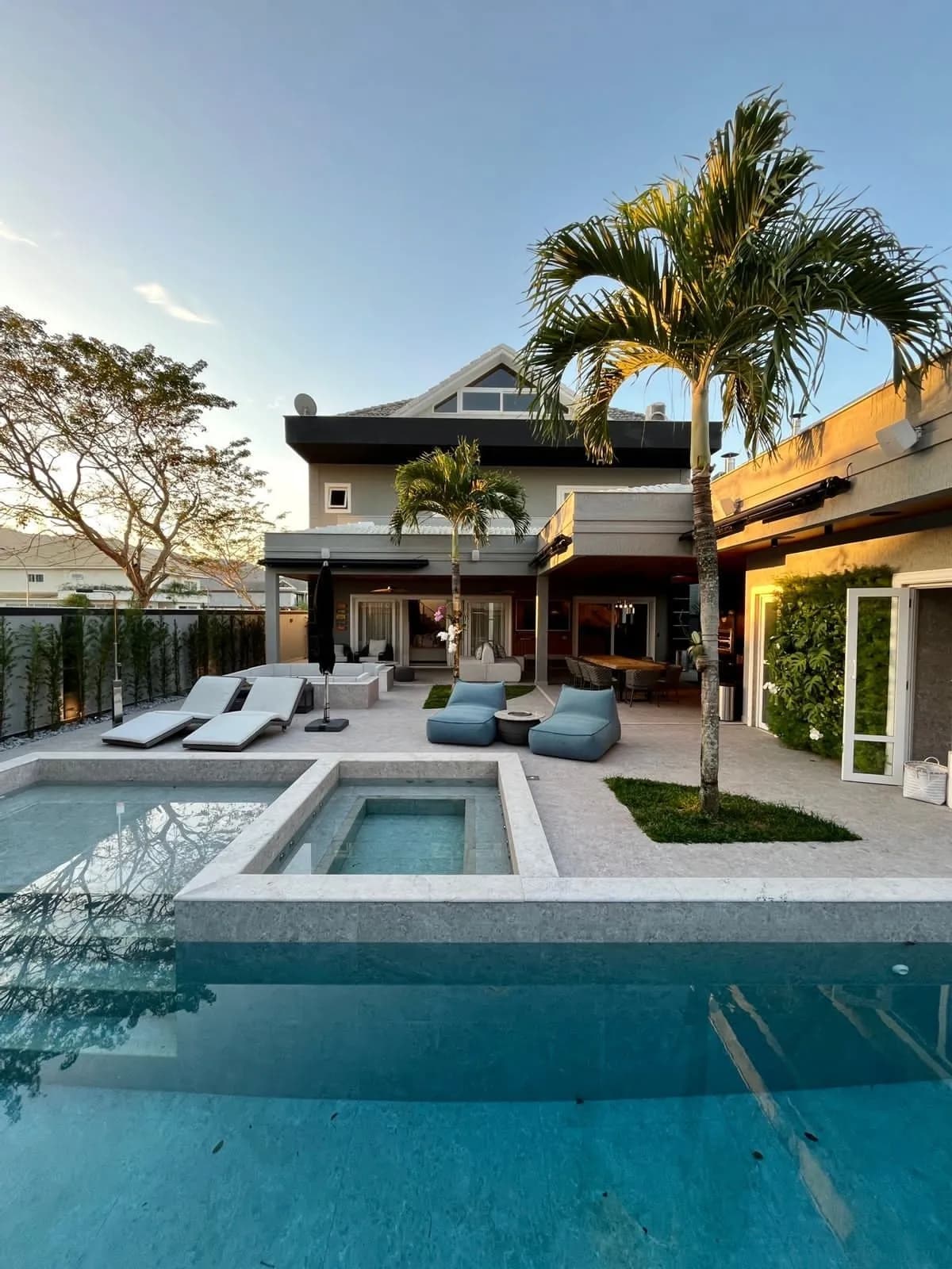 Piscina com revestimento e deck na área de lazer da casa Alphaville 620m²