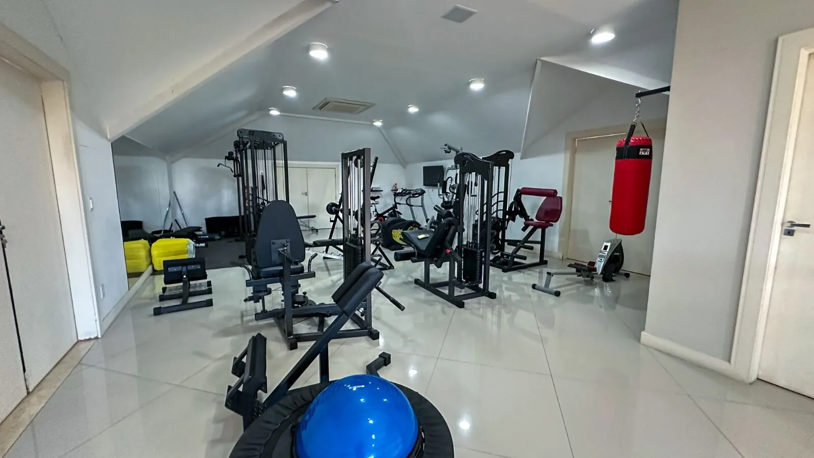 Academia completa com estação multifuncional, saco de boxe e equipamentos profissionais na Casa Alphaville 800m²
