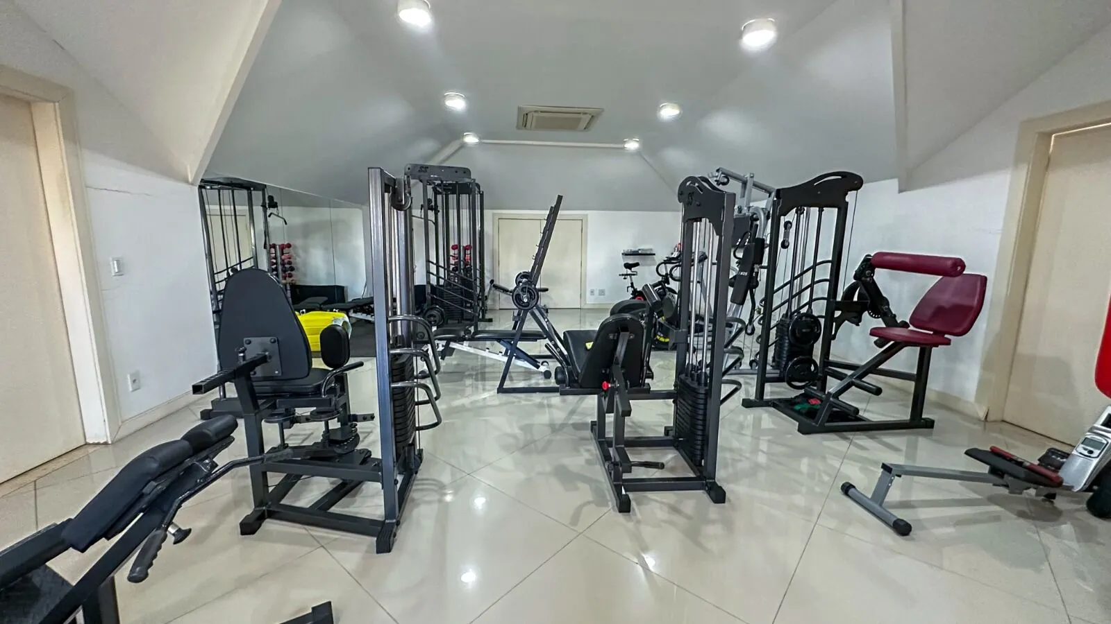 Segundo ângulo da academia privativa com equipamentos de musculação na Casa Alphaville Barra da Tijuca