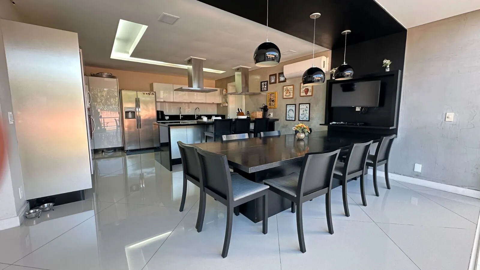 Cozinha americana planejada com eletrodomésticos inox e bancada na Casa Triplex Alphaville 800m²