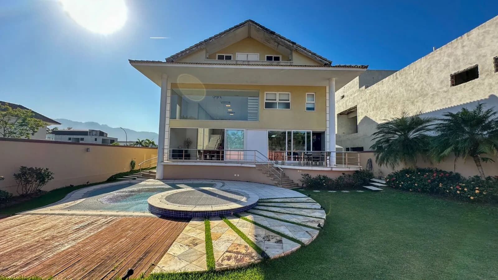 Fachada da casa triplex contemporânea 800m² no Alphaville com piscina, deck de madeira e jardim tropical