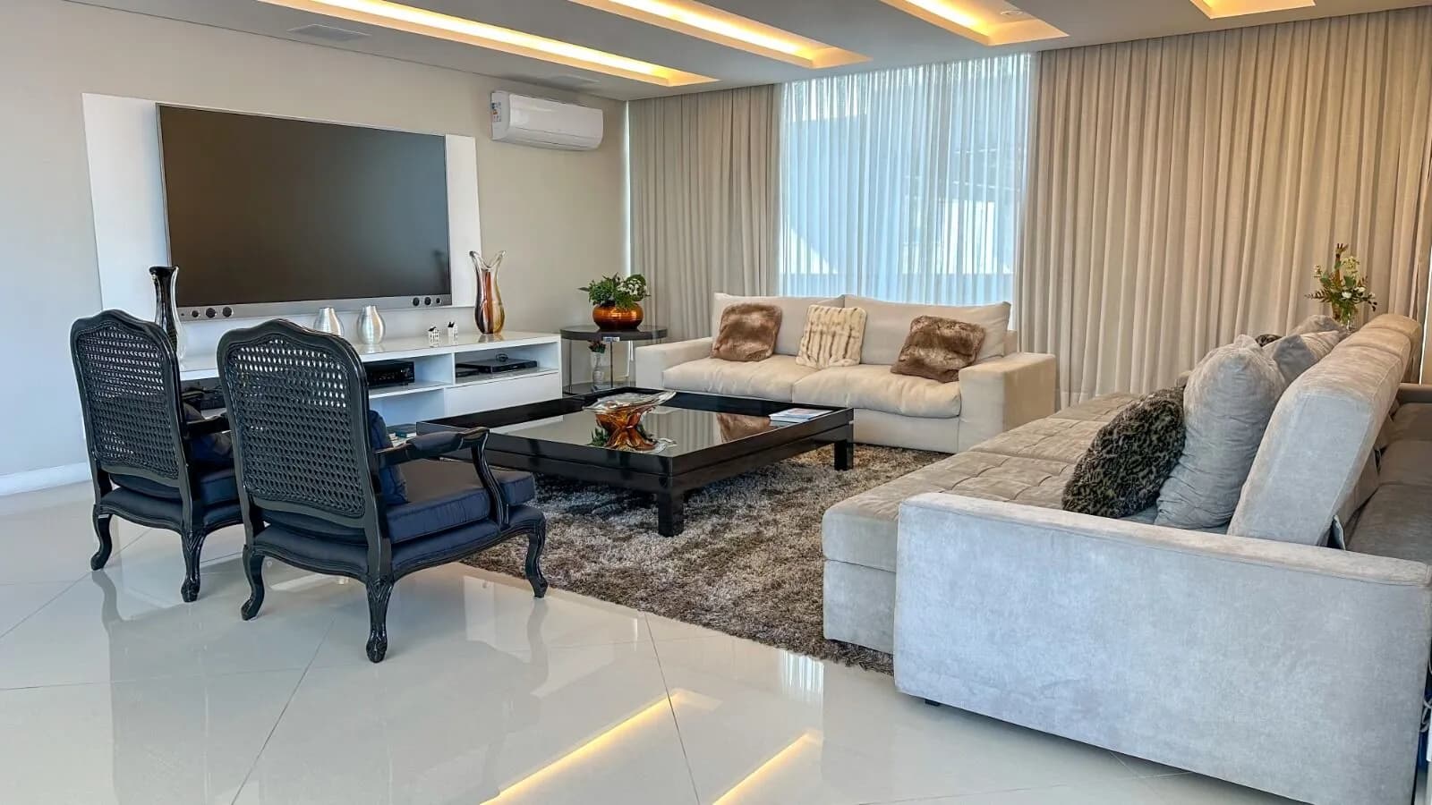 Sala de TV com painel, iluminação embutida e sofás de alto padrão na Casa Alphaville 800m² Barra da Tijuca