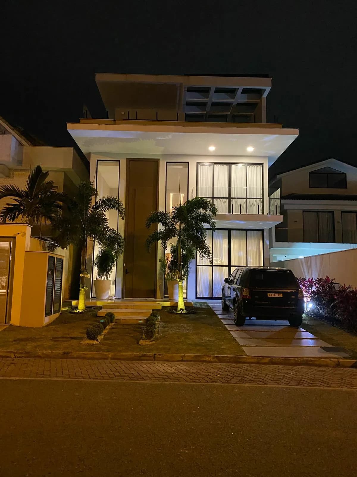 Entrada principal da casa triplex no Alphaville Barra com garagem para 6 veículos e paisagismo